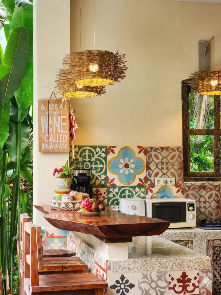 Rustic tropical kitchen with wooden countertop, colorful patterned tiles, woven pendant lights, and tropical fruits.